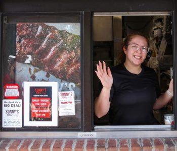 Sonny's employee waves from drive through