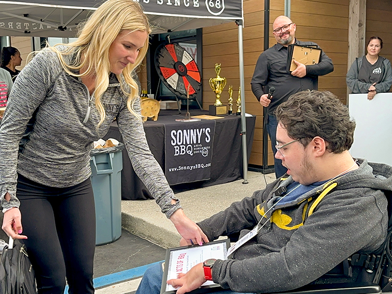 Sonny's Team Member hands Caleb a Random Acts of BBQ certificate after he was sworn in as an honorary firefighter