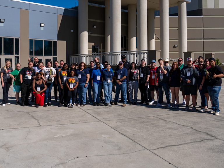 Students in Jr. Pitmaster Class stand outside Wekiva High School for a photo.