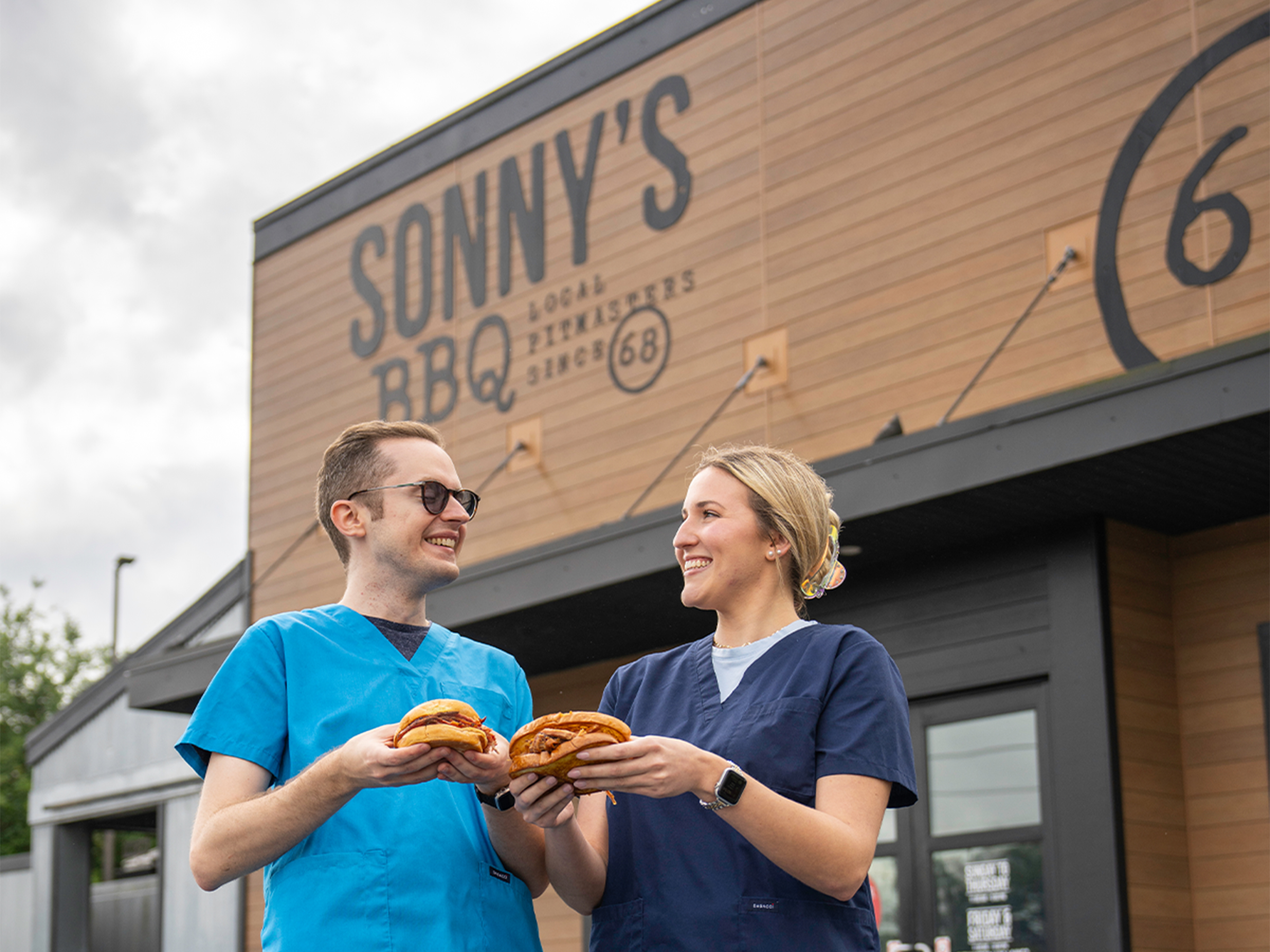 Nurses stand outside Sonny's with pork sandwiches