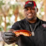 Head Pitmaster Shannon Snell hold St. Louis Rib towards camera
