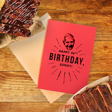 Birthday Card sits on table beside two plates of St. Louis Ribs, card reads 