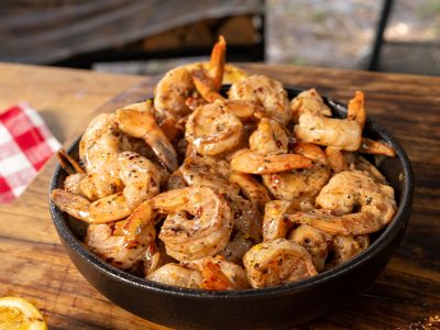 Bowl of Hot Honey Bang Bang Shrimp sits on wood table.