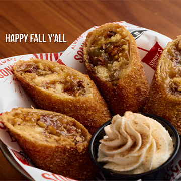 Bowl of Pecan Pie Egg Rolls and Whipped Cream sits on table with text overlay saying 