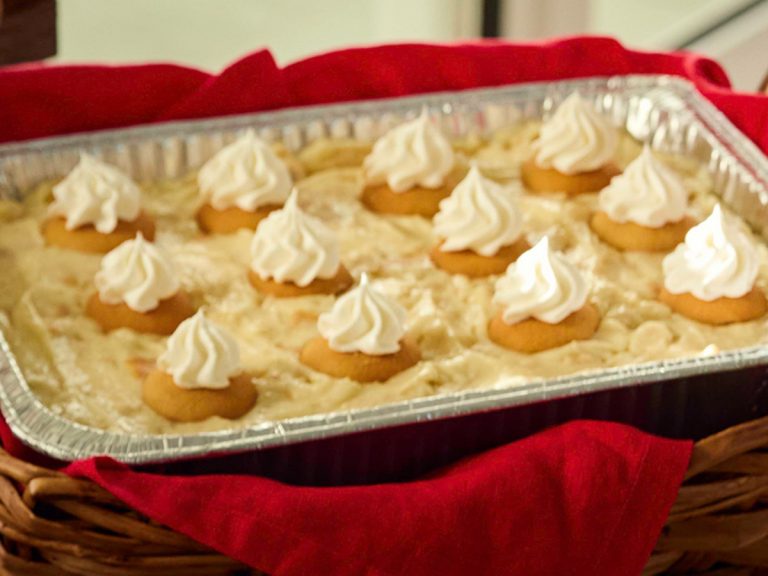 Tin of Sonny's Banana Pudding sits in wicker basket lined with red napkin.