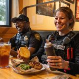 Police officers sit at booth with Pork Big Deals at Sonny's BBQ