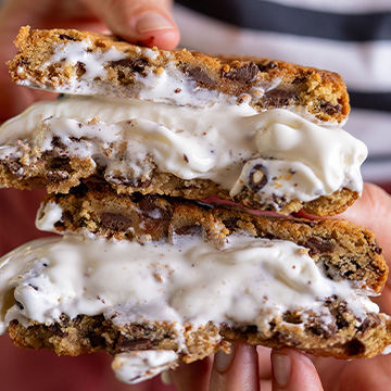 Ice cream cookie sandwich split in half held in front of camera