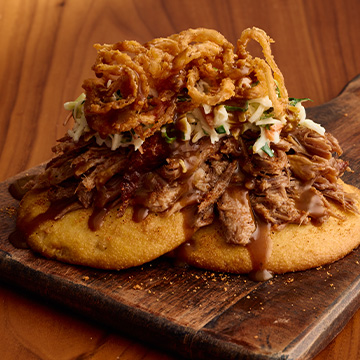 Sonny's Pulled Pork Stack sits on cutting board.