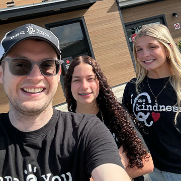 Three people stand outside Sonny's restaurant