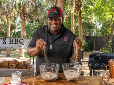 Pitmaster drops pinches of BBQ rubs into bowls