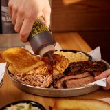 Hand squeezes BBQ Sauce onto Sonny's Sampler, one of Sonny's Originals