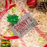 Sonny's Gift Card sits in decorative box filled with paper and holiday decor.