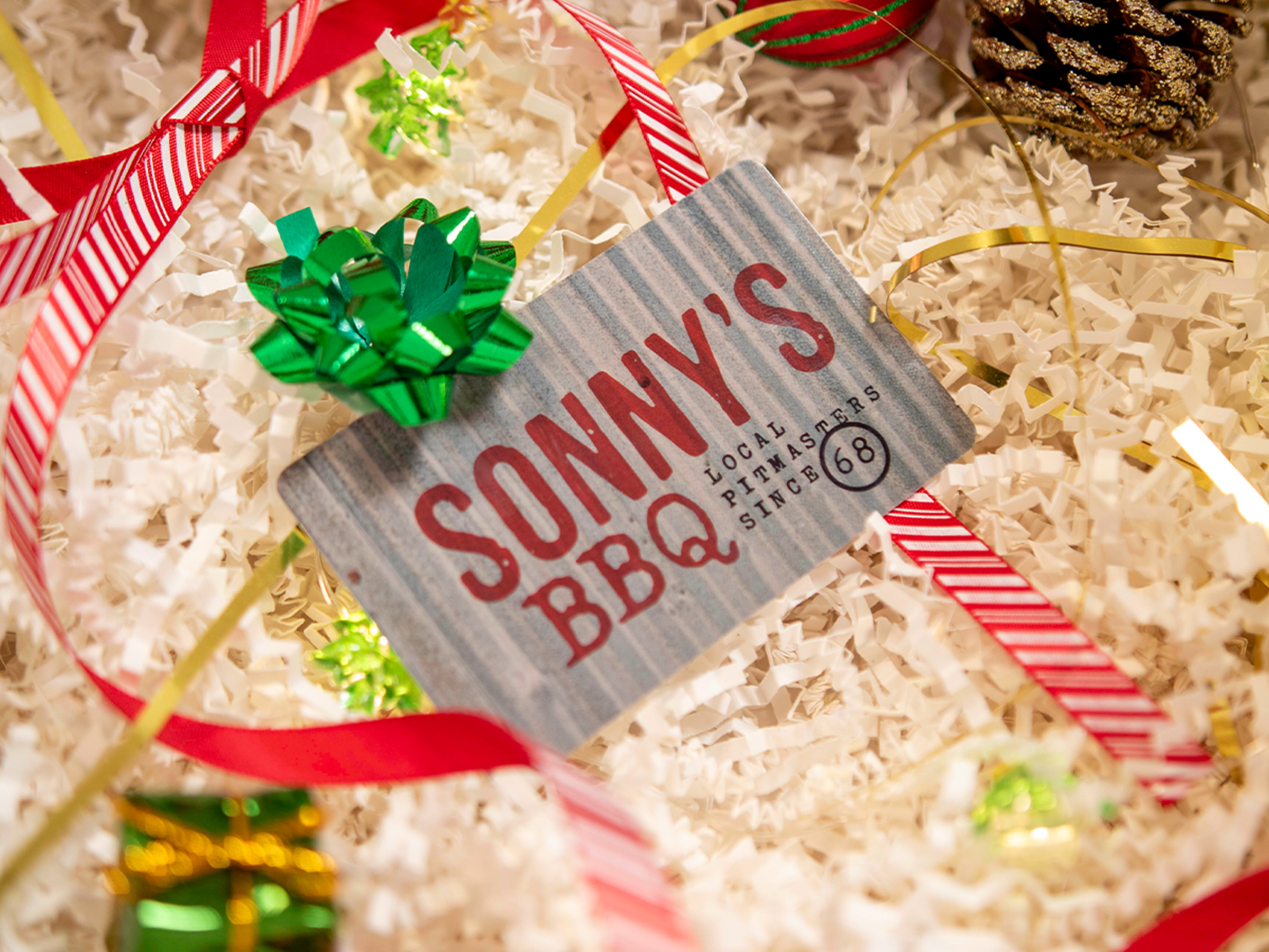 Sonny's Gift Card sits in decorative box filled with paper and holiday decor.