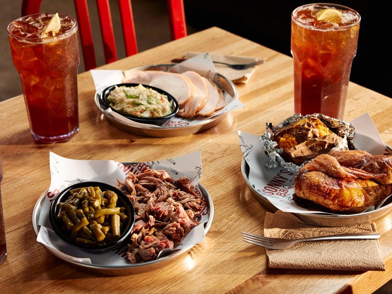 A Pork, Turkey and Chicken Power Plate sit on a Sonny's table with Sweet Teas.