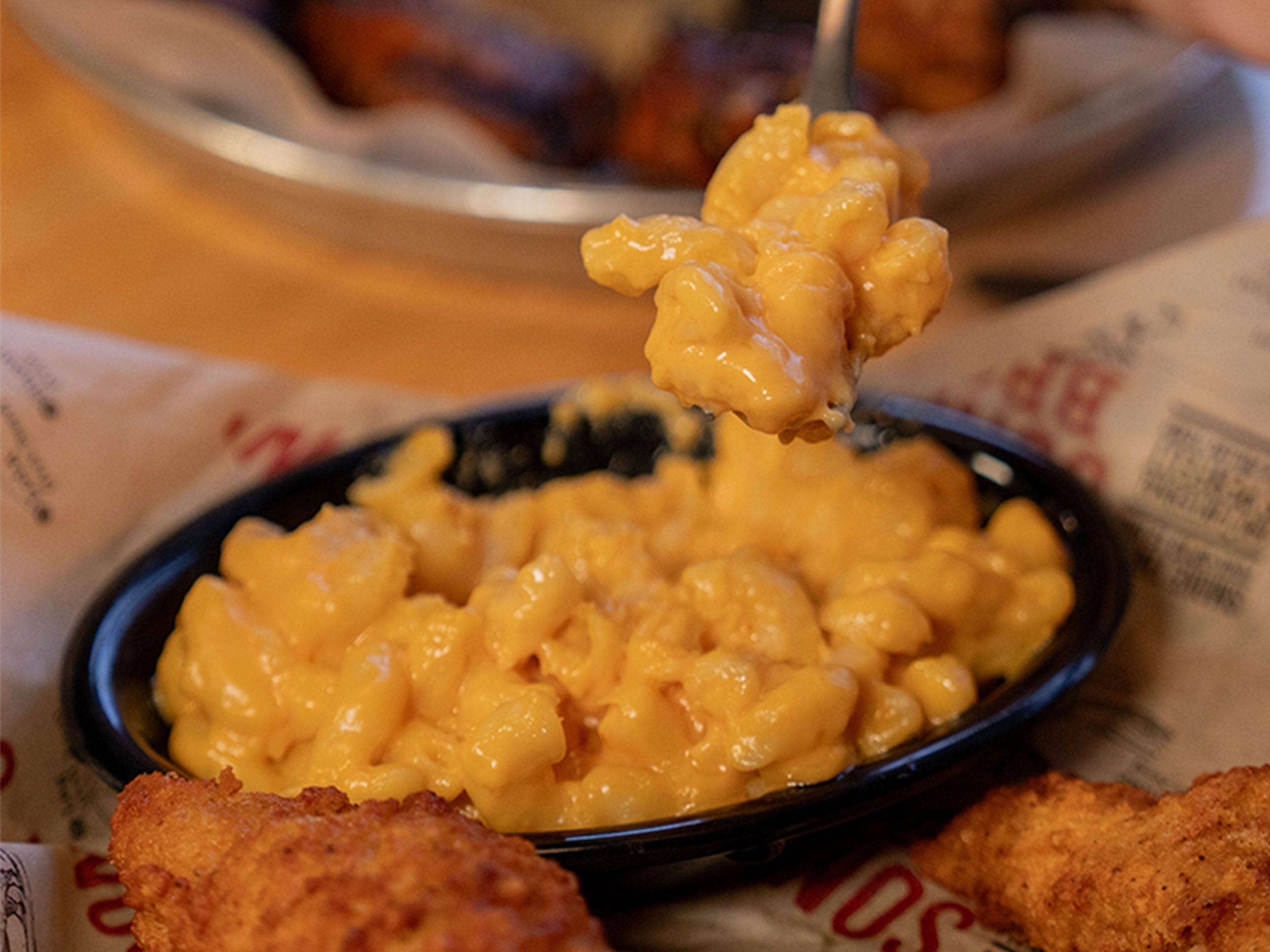 Fork scoops Mac and cheese out of bowl on Sonny's table.