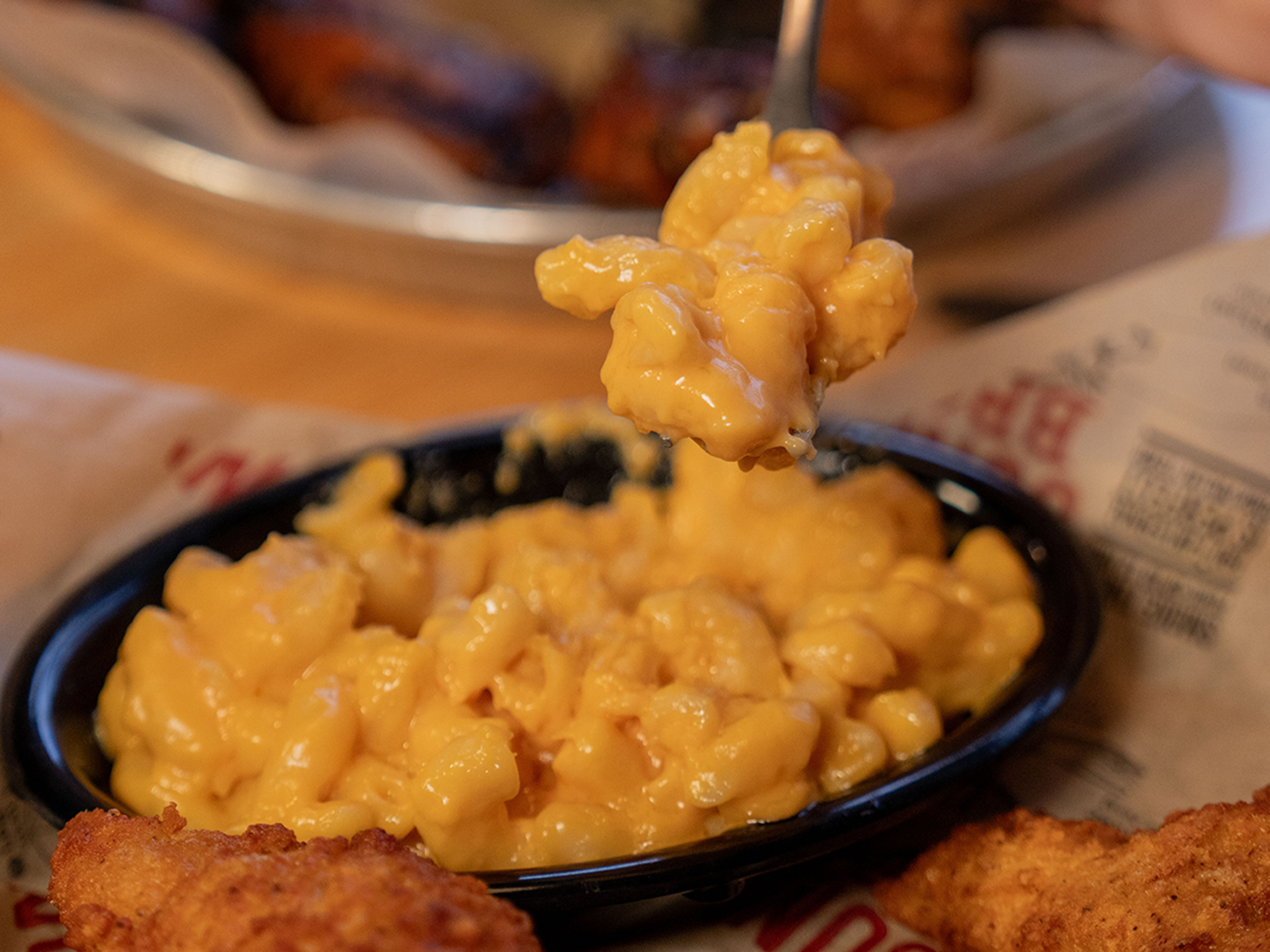 Fork scoops Mac and cheese out of bowl on Sonny's table.