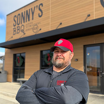 Pitmaster Stands in Front of Sonny's BBQ.