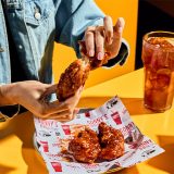Woman sits at table tearing apart chicken tender