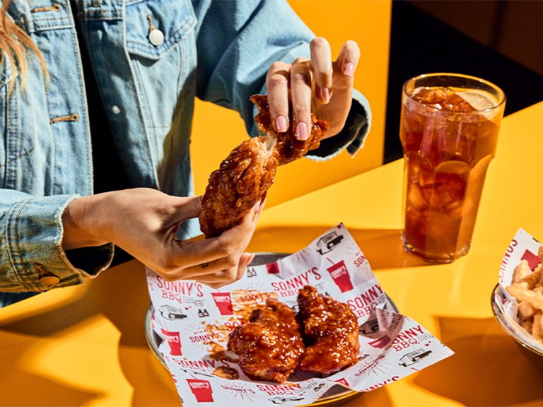 Woman sits at table tearing apart chicken tender