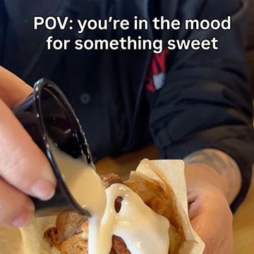 Person drizzles glaze over Cinnamon Apple Bread Pudding