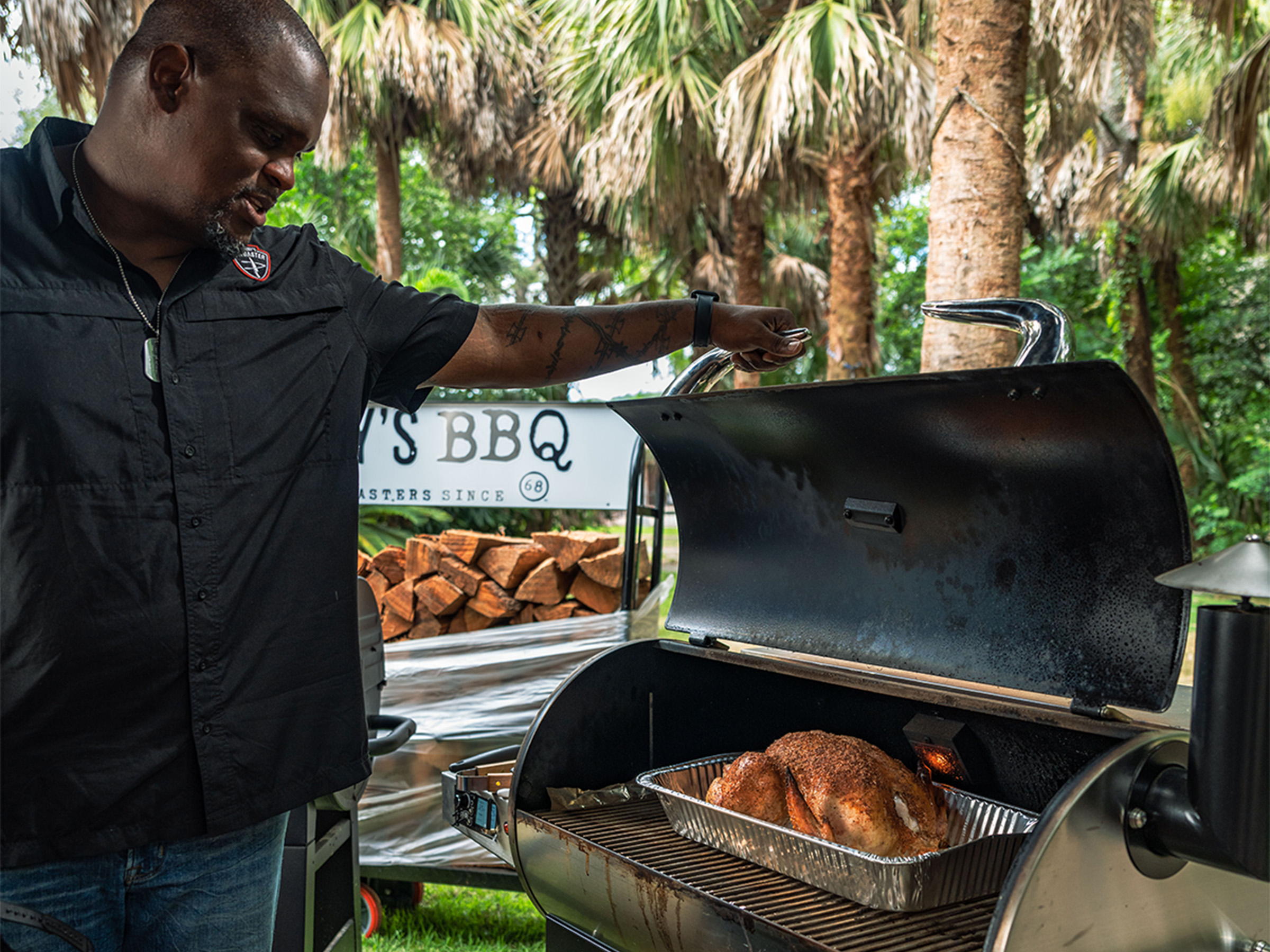 Man opens smoker to reveal turkey cooking inside.