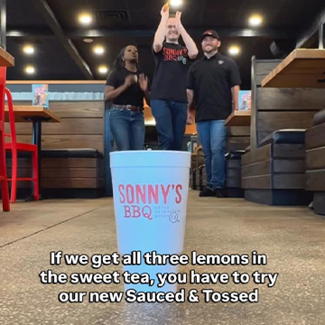 Sonny's BBQ cup in foreground with three people standing behind it