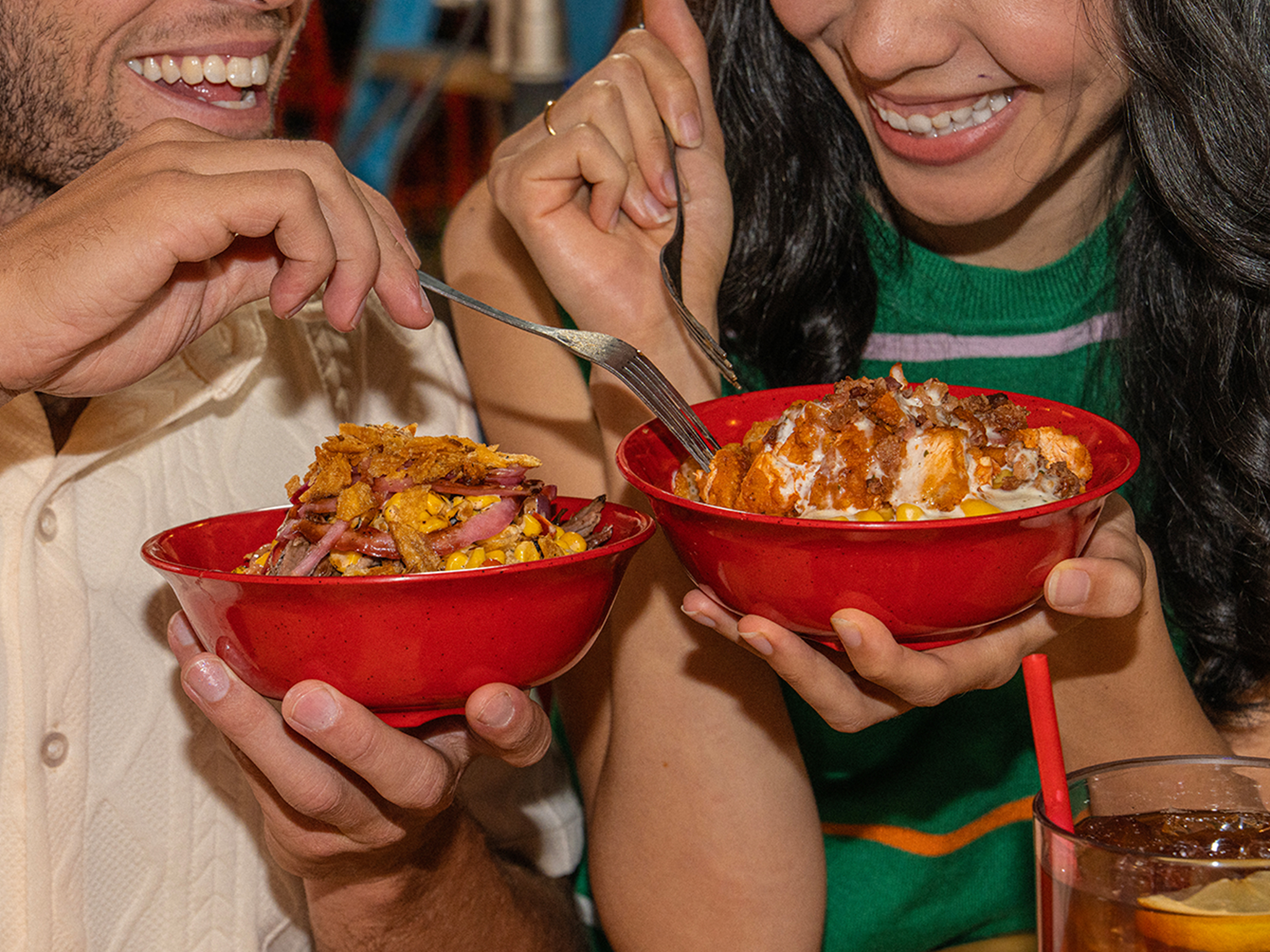 Man and woman smile while holding BBQ Bowls