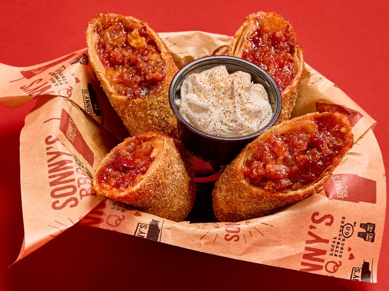 Housemade cherry cobbler in a cripsy spring roll served with cream at Sonny's BBQ.