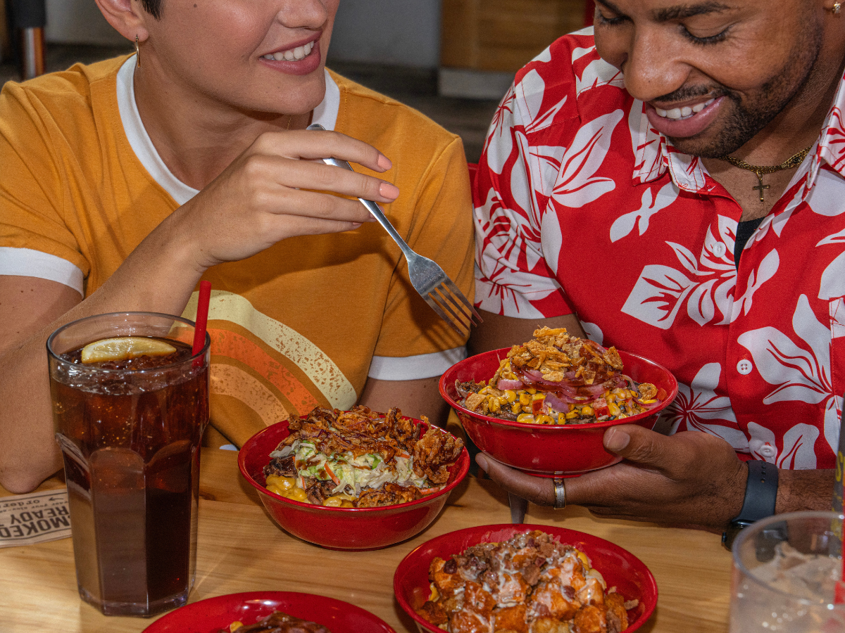 Friends sit at Sonny's table sharing BBQ Bowls