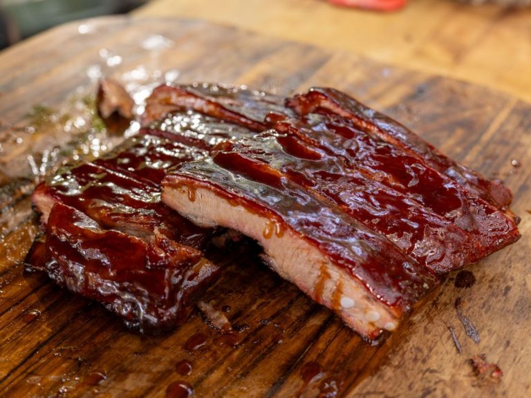 Racks of Sliced St. Louis Ribs are stacked on cutting board